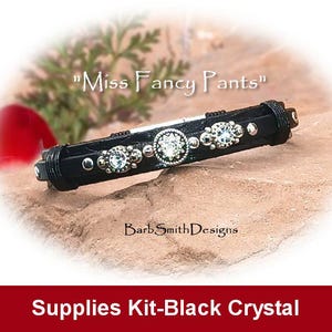 May include: Black leather bracelet with silver accents and clear crystals. The bracelet is labeled "Miss Fancy Pants" and "BarbSmithDesigns".