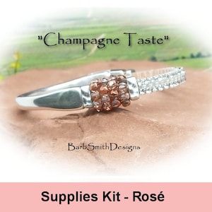 May include: A silver ring with a brown and clear beaded center. The ring is labeled "Champagne Taste" and "Supplies Kit - Rosé".