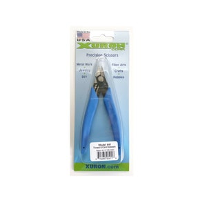 May include: Blue handled thread and cord scissors with a silver blade. The packaging says "Model 441 Thread & Cord Scissors" and "XURON.com".