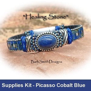 Può includere: Un braccialetto blu e argento con una pietra di lapislazzuli. Il braccialetto si chiama "Healing Stone" ed è un kit di forniture per realizzare un braccialetto Picasso Cobalt Blue.