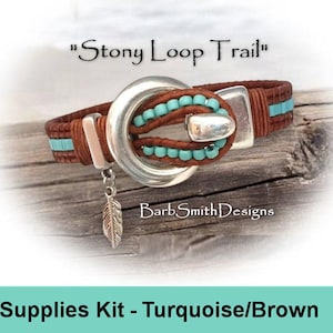 May include: A brown leather bracelet with turquoise beads and silver accents. The bracelet features a large silver buckle and a dangling feather charm. The text "Stony Loop Trail" is above the bracelet.