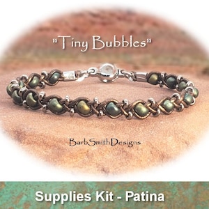 Könnte beinhalten: Ein grünes und braunes Lederarmband mit silbernen Perlen und einem silbernen Verschluss. Das Armband heißt "Tiny Bubbles" und ist ein Zubehör-Set in Patina.