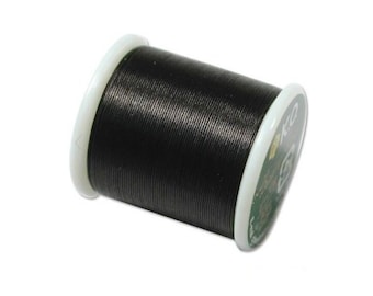 Puede incluir: Una bobina de hilo negro con etiqueta blanca y verde. La etiqueta tiene el texto "100%"