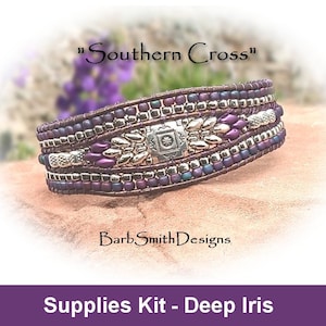 Könnte beinhalten: Ein mehrreihiges Perlenarmband mit einem silbernen Anhänger und violetten Perlen. Das Armband liegt auf einer braunen Oberfläche. Der Text "Southern Cross" und "BarbSmithDesigns" ist sichtbar. Der Text "Supplies Kit - Deep Iris" befindet sich am unteren Rand des Bildes.