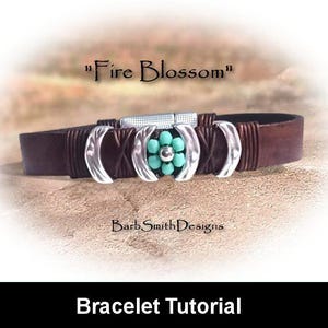 May include: A brown leather bracelet with silver details and a turquoise flower design. The bracelet is inscribed with "Fire Blossom" and "Barb Smith Designs". It has a magnetic clasp and is a bracelet tutorial.