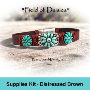 May include: A brown leather bracelet featuring three turquoise-colored flower-shaped beads with silver accents and a silver magnetic clasp. The text "Field of Daisies" and "BarbSmithDesigns" appears above and below the bracelet, with "Supplies Kit - Distressed Brown" at the bottom.