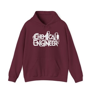 Puede incluir: Una sudadera con capucha de color granate que presenta un estampado gráfico blanco en el pecho. El diseño muestra el texto CHEMICAL ENGINEER estilizado con tuberías, válvulas y equipos industriales integrados en las letras.