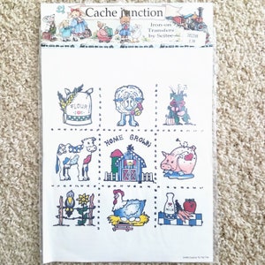May include: A sheet of iron-on transfers featuring a variety of farm-themed images, including a cow, pig, chicken, barn, and bag of flour. The sheet is titled "Cache Junction Iron-on Transfers by Seite".