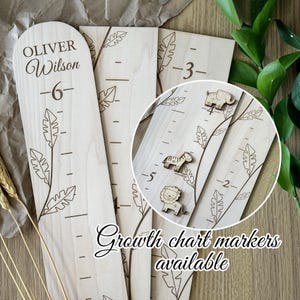 May include: Wooden growth chart with engraved name "Oliver Wilson" and height markings. Features decorative leaf designs and wooden animal markers. The chart measures up to 6 feet.