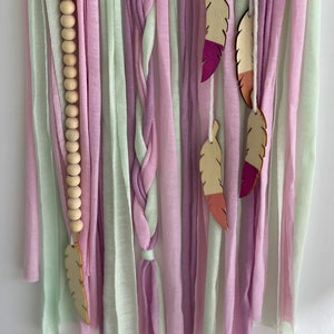 Custom name dreamcatcher for girls made of cotton rope, wooden beads, and wooden feathers.