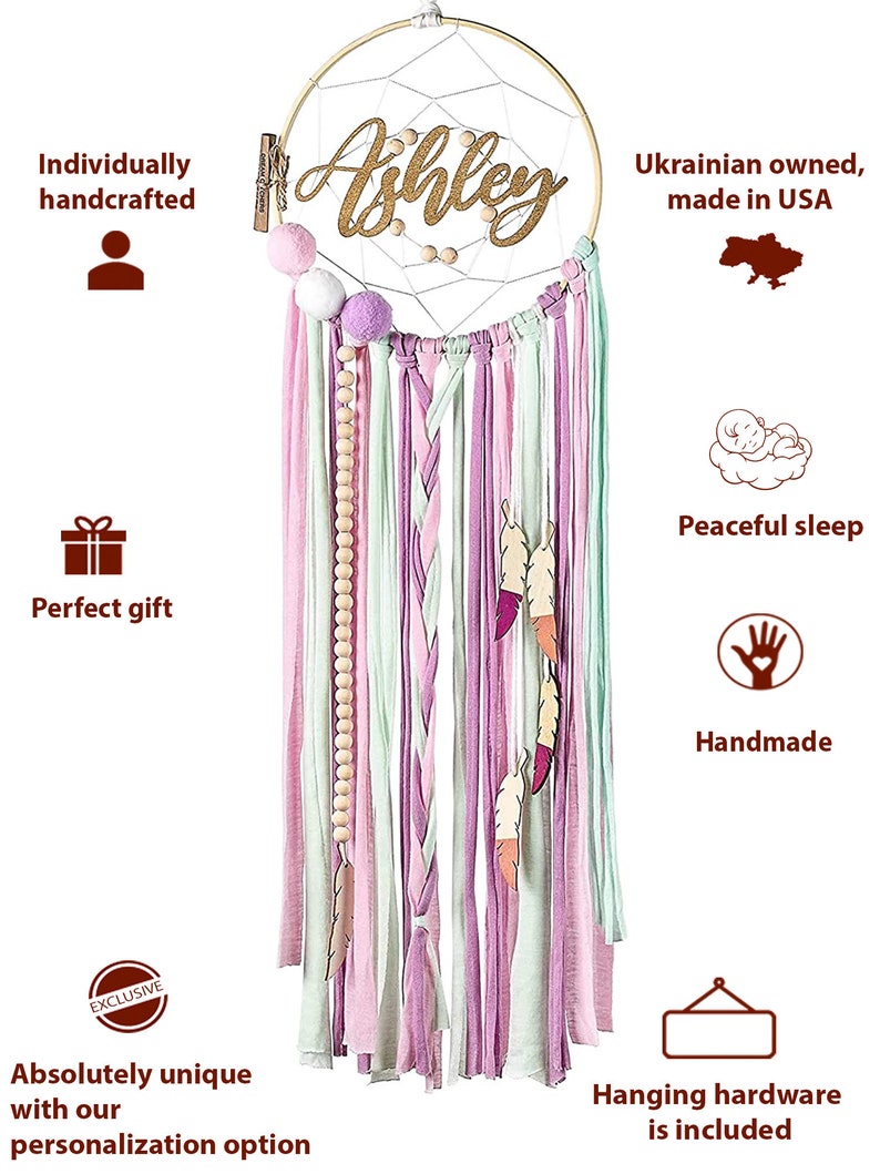 May include: A pink, green, and white dreamcatcher with wooden beads and feathers. The dreamcatcher has a wooden hoop with the name "Ashley" written in gold glitter. The dreamcatcher is handmade and comes with hanging hardware.