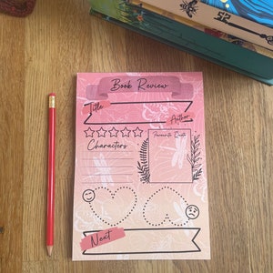 May include: A pink and orange book review template featuring a dragonfly design. The template includes sections for title, author, rating, characters, favourite quote, and next.