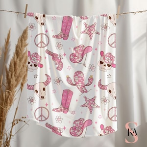 May include: Pink and white fabric with a repeating pattern of cowboy boots, hats, peace signs, stars, skulls, and cacti.