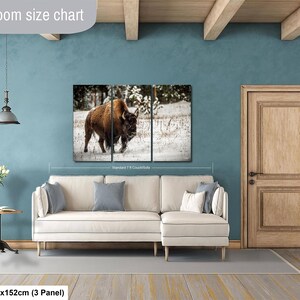 The image is a living room with a large painting of a bison in the snow hanging on the wall. The painting is divided into three panels, and the couch is white with gray pillows. The room has a wooden door and a small table with a vase of flowers. The living room size chart indicates the dimensions of the space, which is 40'60" x 101'15" x (3' Panel).