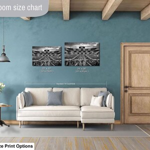 a living room with a white sofa, a wooden door, and a hanging light fixture. Above the sofa, there is a size chart for artwork, indicating the dimensions of the paintings.