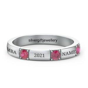 May include: A silver ring with three red gemstones and engraved text: "MBA", "2021", and "NAME".