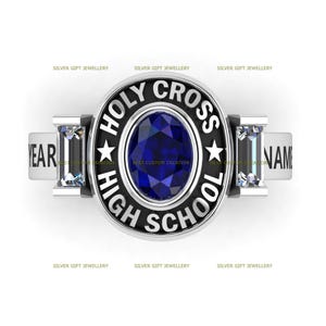 May include: A silver class ring with a blue oval stone and the words "Holy Cross High School" engraved on the face. The ring also has two smaller stones on the sides and the words "Year" and "Name" on the band.