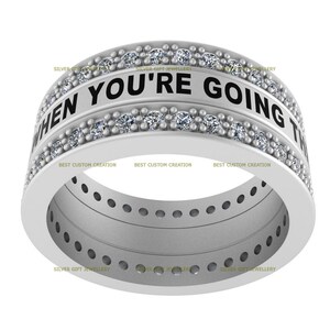 Op de afbeelding: Een zilveren ring met een band van kleine diamanten en de inscriptie "WHEN YOU'RE GOING TO" rond de bovenkant.