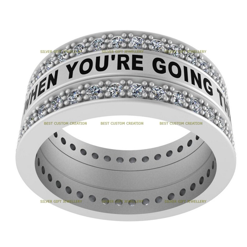 Op de afbeelding: Een zilveren ring met een band van kleine diamanten en de inscriptie "WHEN YOU'RE GOING TO" rond de bovenkant.