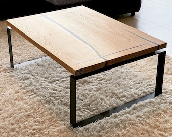 May include: A wooden coffee table with a black metal frame. The table top has a natural wood finish with a black epoxy resin inlay.
