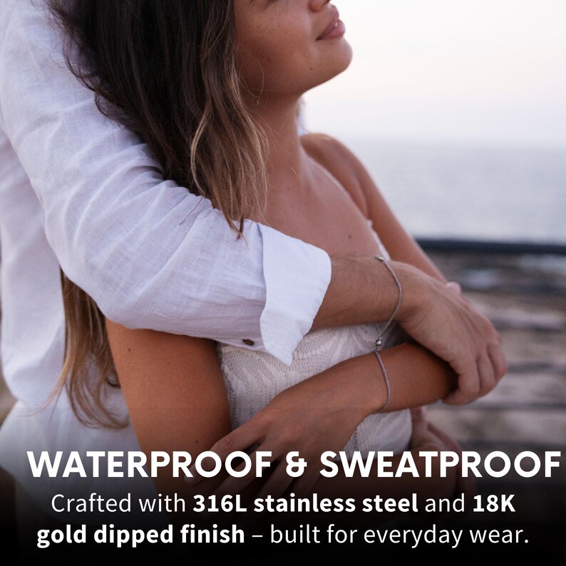 May include: A couple embracing, with the woman's arm around the man's neck. The text "WATERPROOF & SWEATPROOF" is at the bottom of the image. The text "Crafted with 316L stainless steel and 18K gold dipped finish - built for everyday wear." is below the first line of text.