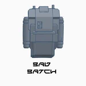 May include: A gray, blocky, 3D model of a spaceship with the text "BAD BATCH" printed below it.