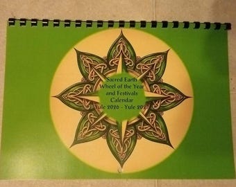 Puede incluir: Un calendario de pared con encuadernación en espiral, fondo verde y un círculo central amarillo con un diseño de estrella de ocho puntas en verde oscuro con nudos intrincados. El texto dice: Sacred Earth Wheel of the Year and Festivals Calendar Yule 2026 - Yule 2027.
