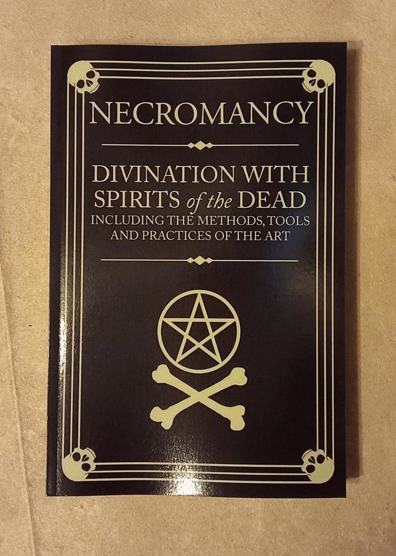 May include: A dark book titled "NECROMANCY" with the subtitle "DIVINATION WITH SPIRITS of the DEAD." The cover features a pentagram, crossed bones, and skull illustrations. The book's design includes a border with skull motifs.