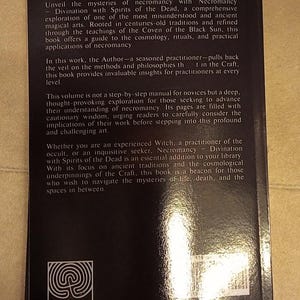 May include: A black book titled "Necromancy Divination with Spirits of the Dead" by Troy Books. The back cover has text about necromancy, rituals, and ancient traditions. The book's logo is a spiral design.