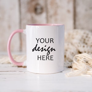 May include: White ceramic mug with a pink rim and handle. The mug has the text "YOUR design HERE" printed on the front.