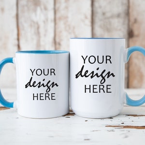 May include: Two white ceramic mugs with blue rims. Both mugs have the text "YOUR design HERE" printed on them.
