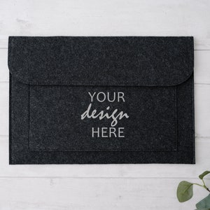 May include: A black felt laptop sleeve with a flap closure. The sleeve has the text "YOUR design HERE" printed on the front.