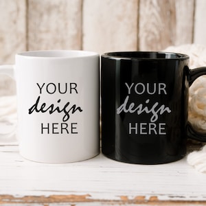 May include: Two ceramic coffee mugs, one white and one black, with the text "YOUR design HERE" on each mug.
