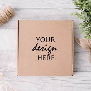 Może przedstawiać: Proste brązowe pudełko kartonowe z nadrukiem "YOUR design HERE" na przodzie.