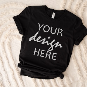 May include: Black t-shirt with the text "YOUR design HERE" printed in white on the front.