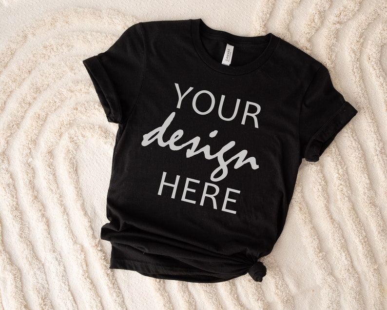 May include: Black t-shirt with the text "YOUR design HERE" printed in white on the front.