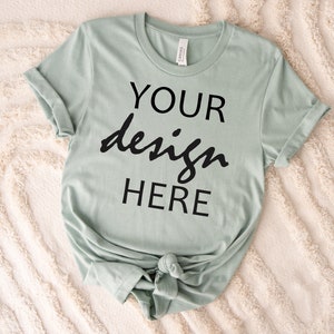 May include: A light green t-shirt with the text "YOUR design HERE" printed on the front.