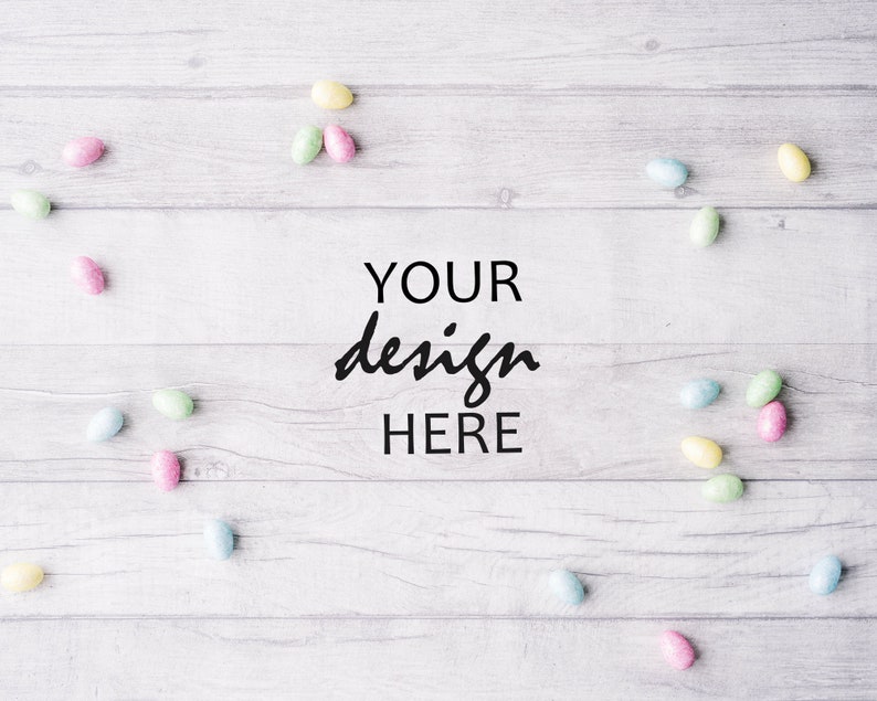 May include: A white wooden background with pastel colored candy eggs scattered around the edges. The text "YOUR design HERE" is in the center of the image.