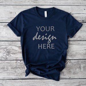 Op de afbeelding: Een marineblauw t-shirt met de tekst "YOUR design HERE" gedrukt op de voorkant.