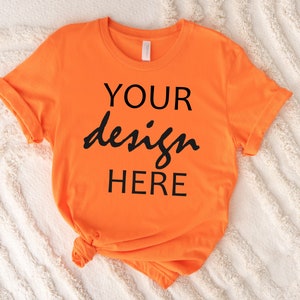 May include: Orange t-shirt with the text "YOUR design HERE" printed in black.
