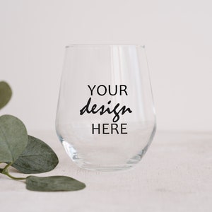 May include: A clear glass wine glass with the text "YOUR design HERE" printed on the side.