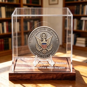 May include: A circular metallic military medal featuring an eagle emblem with a shield, displayed inside a clear acrylic case on a dark wood base. The case front displays the text: USA, 1. August 2025, [Your Name] 2025 Military Medal Recipient, 2025 Distinguished Service Medal Recipient.