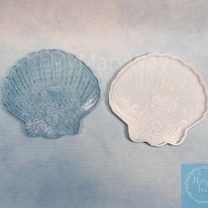 May include: A clear blue seashell resin mold with a white seashell design. The mold is made of silicone and is flexible. The mold is perfect for making resin crafts.