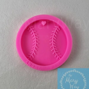 May include: Pink silicone mold shaped like a baseball with white stitching. The mold has a small heart at the top.