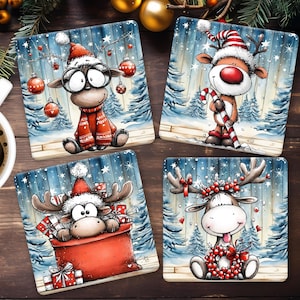 May include: Set of four square Christmas coasters featuring cartoon reindeer in festive scenes. Each coaster has a different reindeer design, including one with glasses and a scarf, and another holding a candy cane. The coasters have a wintery background.
