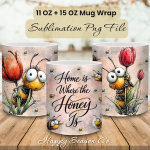 May include: Three white ceramic mugs with a bee and tulip design. The mugs have a wrap-around design with a cartoon bee, red tulips, and the text "Home is Where the Honey Is". The mugs are 11 oz and 15 oz.