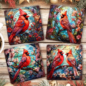 May include: Set of four square coasters featuring vibrant red cardinal birds perched on branches amidst colorful flowers. The coasters have a stained glass effect, with a wooden background.