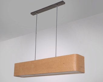 Könnte beinhalten: Eine rechteckige Pendelleuchte mit hellbraunem Holzschirm und dunkler Metallmontageplatte. Das Licht hängt an zwei dünnen Drähten. Der Schirm hat abgerundete Ecken und einen weißen Innenraum.