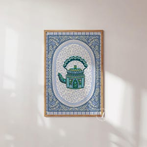May include: A framed print of a blue and green teapot with intricate details on a white background. The teapot is surrounded by a blue and white patterned border.
