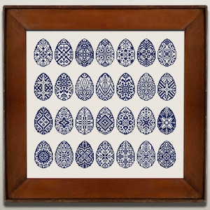 Könnte beinhalten: Ein gerahmtes Kunstwerk mit einer Sammlung von 36 blauen und weißen, gemusterten Ostereiern. Die Eier sind in einem Rastermuster in einem braunen Holzrahmen angeordnet.